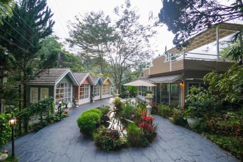 a courtyard of a house with flowers and plants at ปางสูงเฮาส์ pangsung house บ้านมินิ เหลือง in Ban Pang Bo Hu Bon