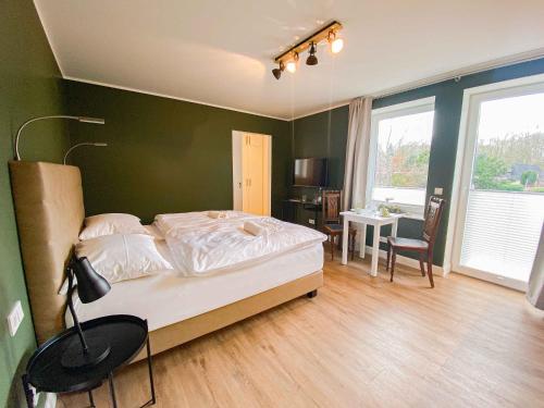 a bedroom with a bed with a green wall at Gästehaus Alte Bücherei in Mittelangeln