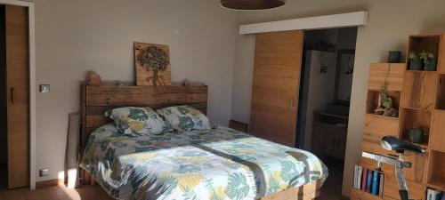 a bedroom with a bed with a wooden headboard at Chambres d hôtes les Romarins in Cantaron