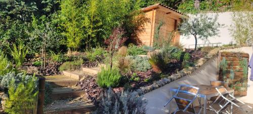 a garden with a table and chairs in it at Chambres d hôtes les Romarins in Cantaron