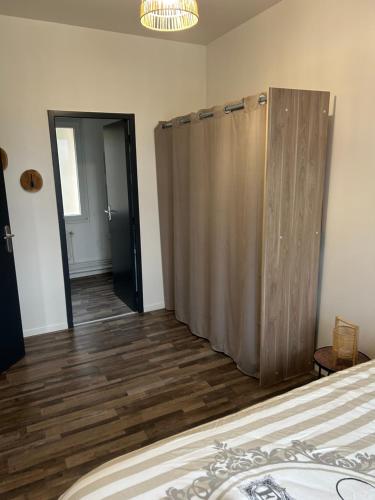 a bedroom with a bed and a wooden floor at Appartement bord de seine in Orival