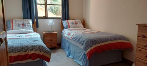 a bedroom with two beds and a window at The Dairy in Teignmouth