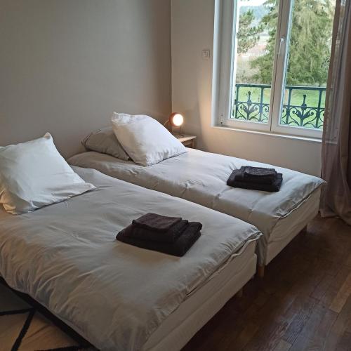 - 2 lits avec serviettes dans une chambre avec fenêtre dans l'établissement Gîte Le Français VERDUN 4 pers,climatisé,grand garage,jardin 3 étoiles, à Belleville-sur-Meuse