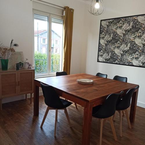 une salle à manger avec une table et des chaises en bois dans l'établissement Gîte Le Français VERDUN 4 pers,climatisé,grand garage,jardin 3 étoiles, à Belleville-sur-Meuse