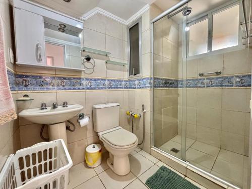 a bathroom with a shower and a toilet and a sink at Apartamento a beira-mar in Capão da Canoa