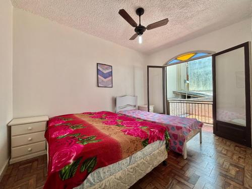 a bedroom with a bed and a ceiling fan at Apartamento a beira-mar in Capão da Canoa