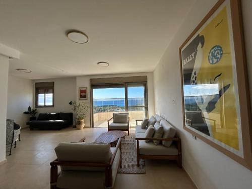 a living room filled with furniture and a large window at The Kingfisher -- Sea, Nature, You A relaxing vacation for up to 6 people in Giv‘at Olga