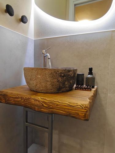 un lavandino da bagno su un bancone in legno con specchio di Interno2 a Taranto