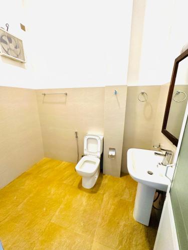 a bathroom with a white toilet and a sink at Tranquil Edge Villa in Haputale