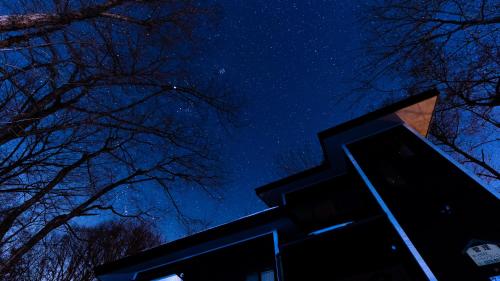 a night view of the starry sky above a building at クラレンス-森の中でBBQと4Kプロジェクターが楽しめる北軽井沢の貸切Villa- in Kita-karuizawa