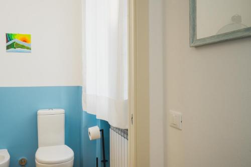 a bathroom with a white toilet and a curtain at Lucignolo in Fucecchio