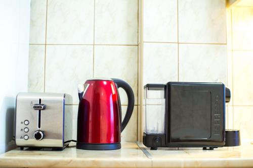 un appareil rouge assis sur un comptoir à côté d'un four micro-ondes dans l'établissement Vándor Vendégház, à Szeged