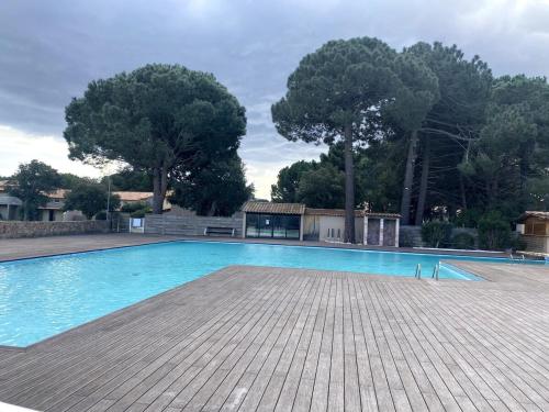 une piscine vide avec des arbres en arrière-plan dans l'établissement Studio Corse entre mer et maquis cala rossa, à Lecci
