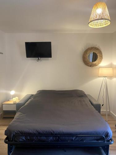 une chambre avec un lit et une télévision au mur dans l'établissement Studio Corse entre mer et maquis cala rossa, à Lecci