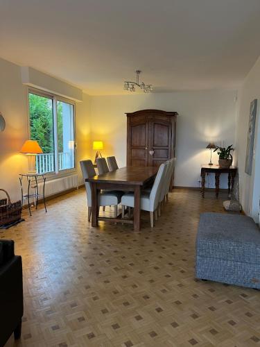 un salon avec une table et des chaises en bois dans l'établissement Maison avec grand jardin - House with large garden, à Fagnières