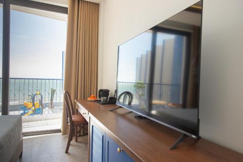 a hotel room with a large flat screen tv at LCV Mũi Né Resort in Mui Ne