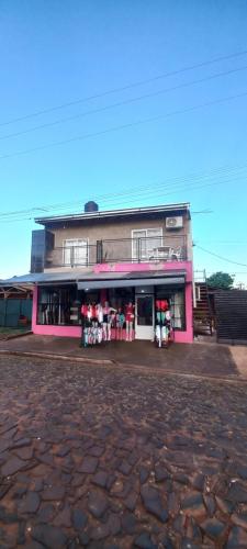 a pink building with a store in front of it at JeiDanApart alojamiento in Puerto Iguazú