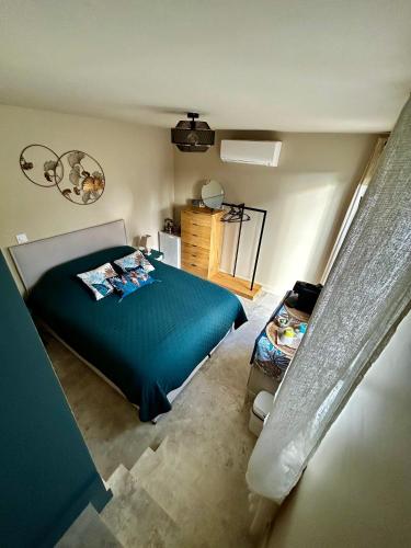 - une chambre avec un lit bleu dans l'établissement Le clos Mirondin, à Six-Fours-les-Plages