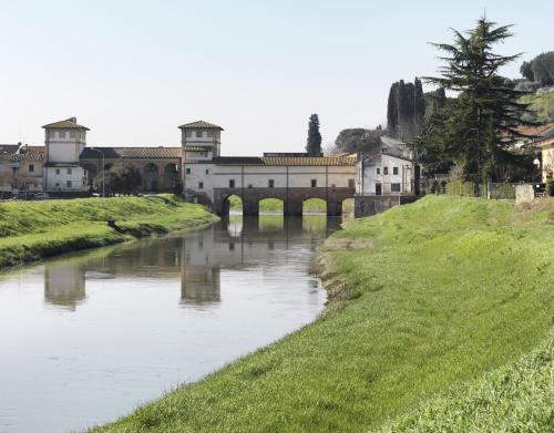 a river with a bridge and buildings in the background at Lucignolo in Fucecchio