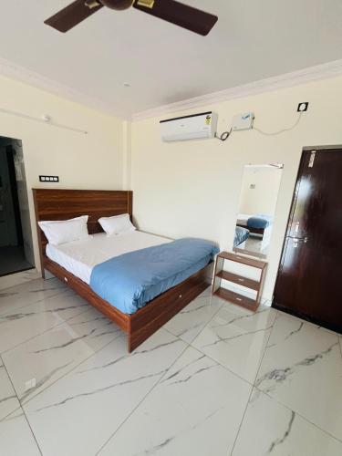 a bedroom with a bed and a ceiling fan at Blue Waves Beach Resort in Vetāpālem