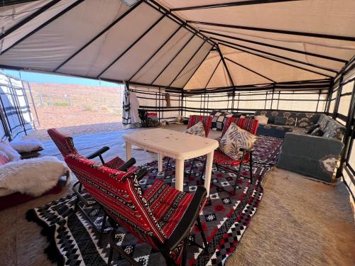 a room with a table and chairs in a tent at مخيم عروق الجوفاءOroj aljofa camp in Ţawī Sulaym