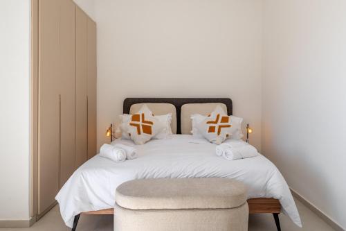 a bedroom with a white bed with pillows and a chair at Villa Yas, Heated Pool, 15min from City Center, 4 Bedrooms, Private Cook and Airport Pickup in Marrakech