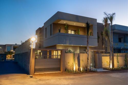 a building with a palm tree in front of it at Villa Yas, Heated Pool, 15min from City Center, 4 Bedrooms, Private Cook and Airport Pickup in Marrakech