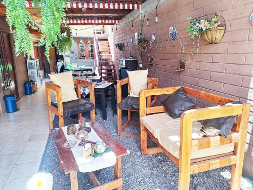 a patio with chairs and a table and a cat sitting on a couch at Hostal Mintaka in San Pedro de Atacama