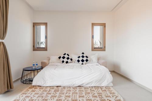 a white bedroom with a bed with two pillows on it at Villa Yas, Heated Pool, 15min from City Center, 4 Bedrooms, Private Cook and Airport Pickup in Marrakech