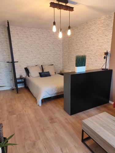 a bedroom with a bed and a brick wall at Studio Cosy Elancourt, Les terrasses d'Héricé in Élancourt