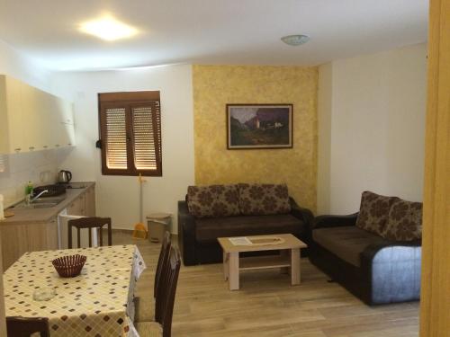 een woonkamer met een bank en een tafel bij Apartments Md Lux in Sutomore