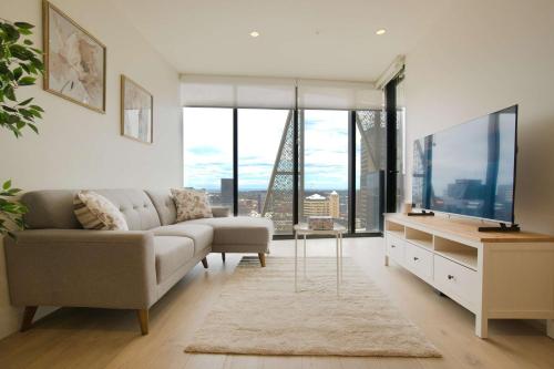 a living room with a couch and a tv at Luxury Apartment in Rundle Mall with Beautiful City Views in Adelaide