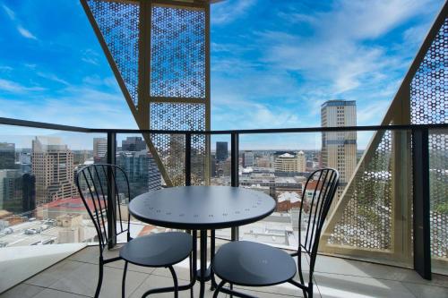 a table and chairs on a balcony with a view at Luxury Apartment in Rundle Mall with Beautiful City Views in Adelaide