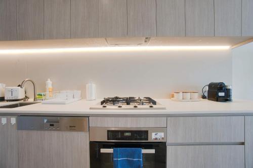 a kitchen with a stove and a counter top at Luxury Apartment in Rundle Mall with Beautiful City Views in Adelaide
