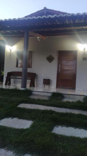 a house with a table and a wooden door at Casa de Campo na Serra in Ibiapina
