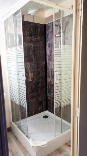 - une douche avec une enceinte en verre dans l'établissement Le Hangar, à Chambretaud