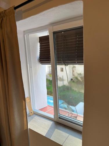 a window with a view of a car outside at Casa Cueva in Setenil
