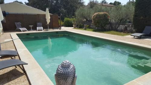 une piscine avec de l'eau bleue dans une cour dans l'établissement Villa la Cigaline, à Lauris