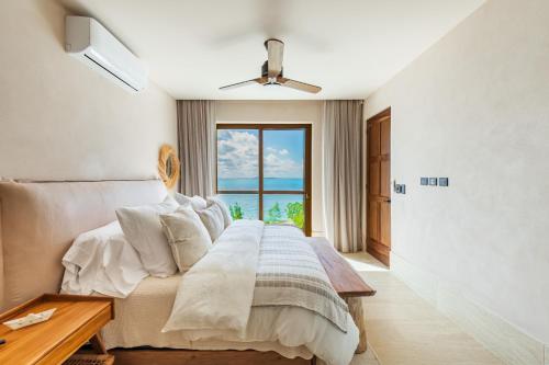 a bedroom with a bed and a large window at Artila Beach Condos, Isla Mujeres in Isla Mujeres