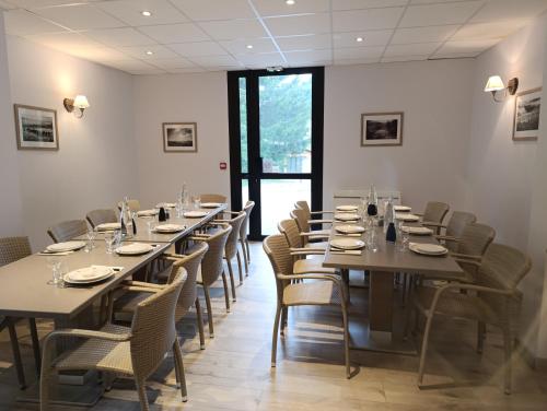 une salle à manger avec de longues tables et des chaises dans l'établissement L'auberge du Berger, à Le Vernet