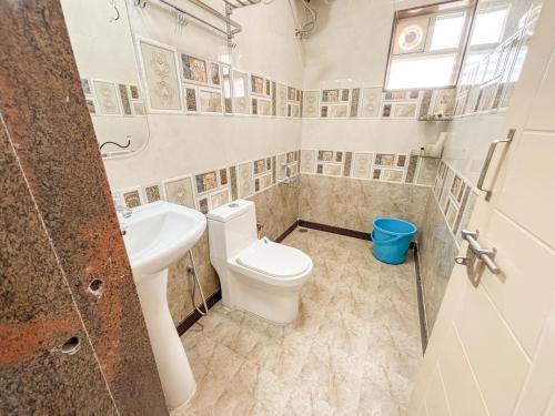 a bathroom with a toilet and a sink at Visla Stay Service Apartment near DLF Newtown in Bengaluru