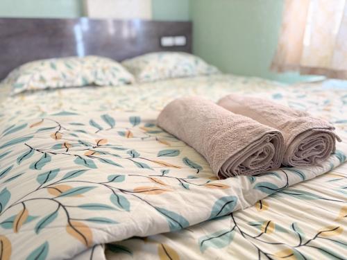 a bed with two towels and pillows on it at Visla Stay Service Apartment near DLF Newtown in Bengaluru