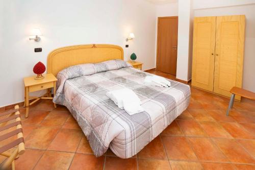 a bedroom with a large bed with a wooden headboard at Le Tartarughe Aparthotel in Letojanni