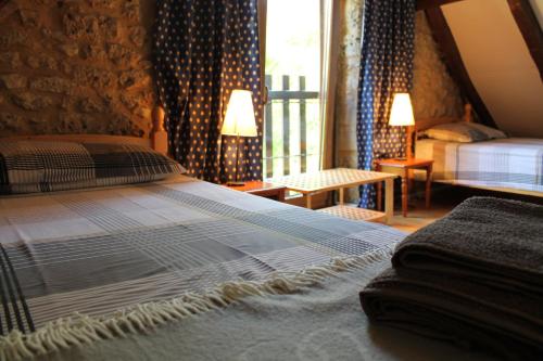 a bedroom with a large bed and a window at Gites le Sud, La Petite Grange in Puybrun