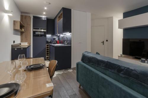 - un salon avec un canapé et une table avec des verres à vin dans l'établissement Le Lyret - Au Centre avec Vue Spectaculaire, à Chamonix-Mont-Blanc