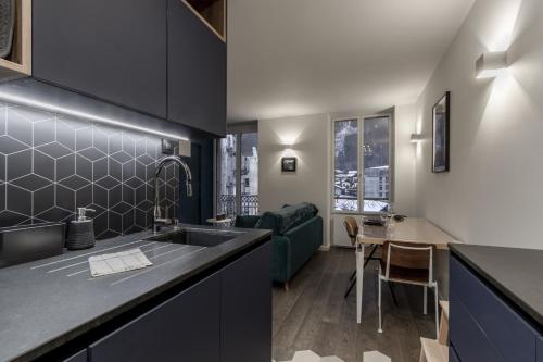 une cuisine avec un évier et un salon dans l'établissement Le Lyret - Au Centre avec Vue Spectaculaire, à Chamonix-Mont-Blanc