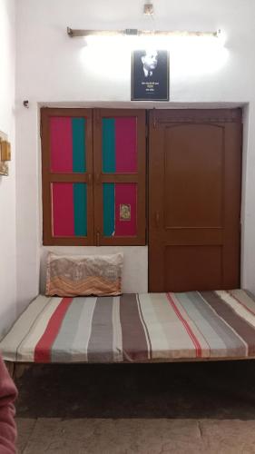 a bed in a room with colorful glass doors at kesharwani homes in Prayagraj