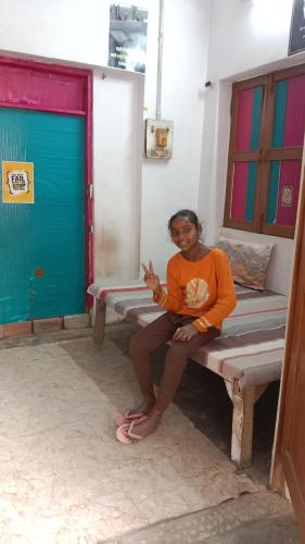 a woman sitting on a bench in a room at kesharwani homes in Prayagraj
