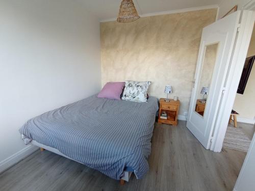 une petite chambre avec un lit et un miroir dans l'établissement Lovely T2 only 30 minutes away from Paris, à Yerres