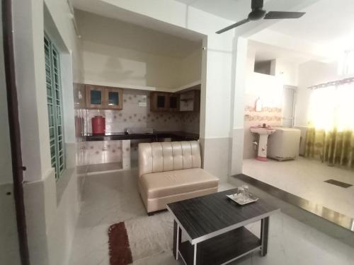 FaizābādVed Vatika Homestay的客厅里有一张沙发和一张桌子。